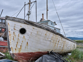 Abandoned fishing boat on a strip of land on the Homer Spit in Alaska