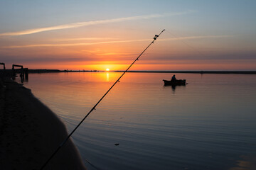 Fishing rod spinning, Fishing rod in rod holder and boat due the fishery day at the sunset. Rod...