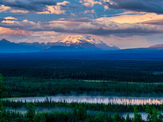 The beautiful snow capped mountains of the Wrangell-St Elias range with early morning mist and fog at sunrise