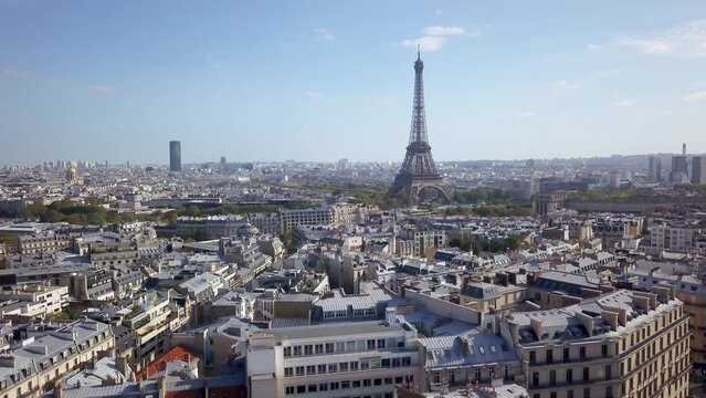 Aerial cinematic drone Paris France Eiffel Tower famous historic landmark from a distance mid day late summer romantic blue sky surrounded by buildings upward motion