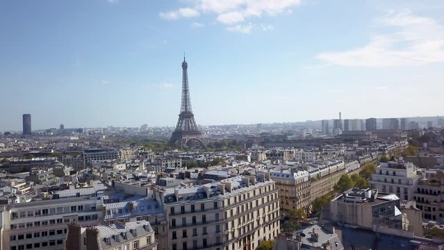 Aerial cinematic drone Paris France Eiffel Tower famous historic landmark from a distance mid day late summer romantic blue sky surrounded by buildings pan circle to the right motion