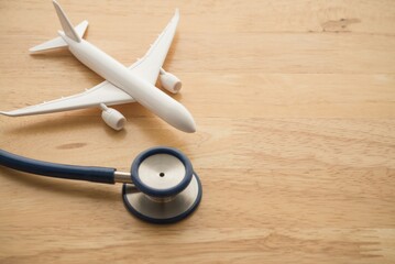 Airplane and stethoscope on wooden background with copy space. Going abroad for medical care....