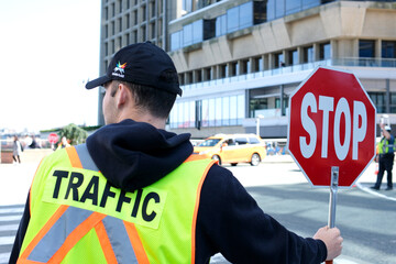 A construction road worker stopping traffic, holding a stop sign. canada Vancouver 2023