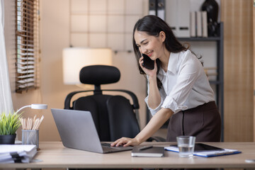 Happy caucasian young Asian woman using smart phone cellphone for calls, social media, mobile application online in office money financial planning Business And Education Concept.