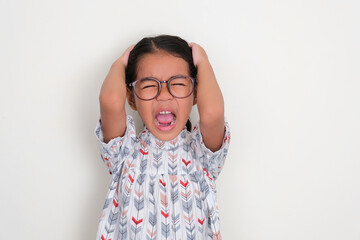 Asian little girl grabbing her hari and scream showing stressed expression - obrazy, fototapety, plakaty