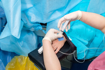 The doctor injects anesthesia with a syringe into the arm of a patient lying on the operating table. Anesthetize the patient during surgery.