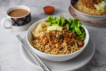 Mie ayam, noodles with chicken and vegetables, Indonesian traditional food in grey texture background.