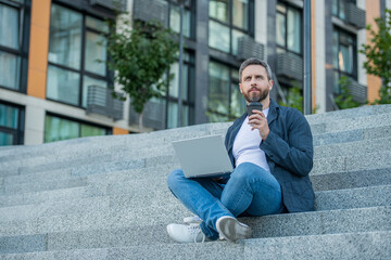 image of freelancer man with computer. freelancer man with laptop outdoor. freelancer man