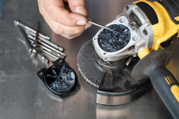 man open up the gear box or Gear housing of old angle grinder  and refill with grease in an angle...