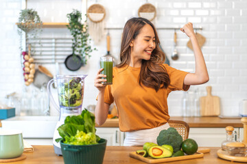 Portrait of beauty healthy asian woman making green vegetables detox cleanse and green fruit smoothie with blender.young girl drinking glass of smoothie, fiber, chlorophyll in kitchen.Diet, healthy