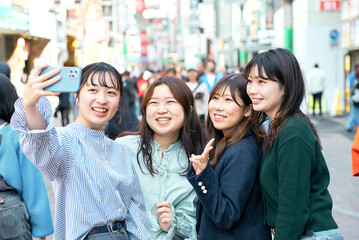 街中で自撮りする4人の女性達