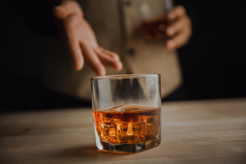 Bartender serving whiskey on wooden bar ,Close-up shot of whiskey glass