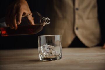 Bartender serving whiskey on wooden bar ,Close-up shot of whiskey glass