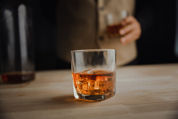 Bartender serving whiskey on wooden bar ,Close-up shot of whiskey glass