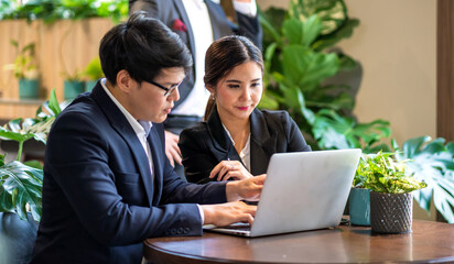 Group of asian business colleague team discussing meeting strategy sharing idea with marketing job project.Creative business work with laptop computer in green plant terrace decorated workloft