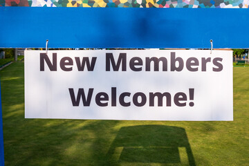 new members welcome signage black block letters on white foam core hanging from blue wooden cross piece room for text - obrazy, fototapety, plakaty