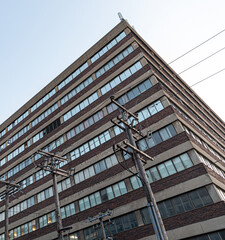 vue d'en bas du coin d'un immeuble industriel à plusieurs étages en brique avec des fenêtres 