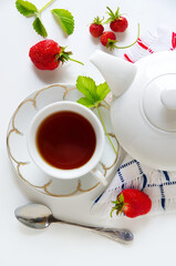 Delicious breakfast of tea, fresh bread rolls with sesame seeds and strawberries. isolated on white background. top view

