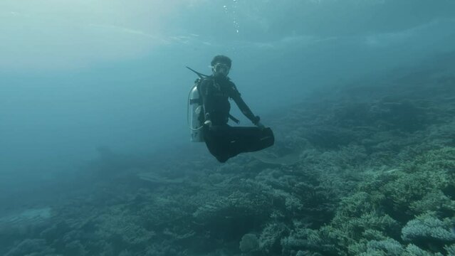 Scuba diver floating underwater in Budda position in 4k