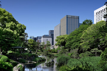 Obraz premium Looking at high-rise office buildings in Hibiya Marunouchi from Shinji Pond, Hibiya Park, Tokyo. Taken May 2023.
