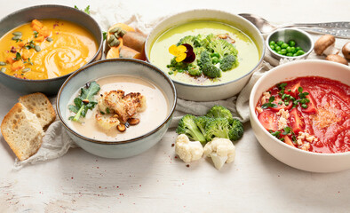 Composition with various soups, ingredients and space for text on white background. Healthy food.