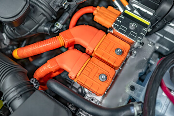 Powerful orange contacts of a hybrid automobile engine with elements of electric drive units
