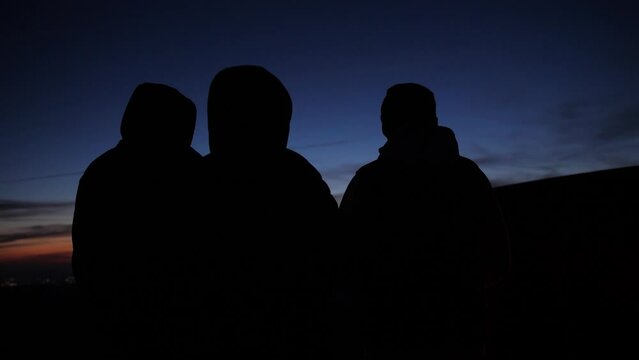Slow motion of three friends socializing outdoors during a camping trip.