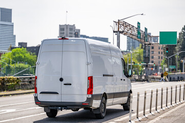 Spacious commercial cargo mini van making delivery driving on the urban city street © vit