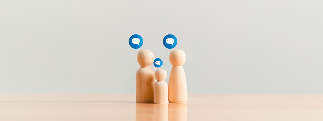 Family persons chatting together by wooden figure models on table. People lifestyle and relationship caring and understanding concept. Love conversation and communication theme.
