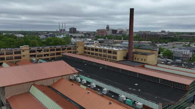 Drone timelapse video moving up to wide shot of downtown Lansing, Michigan skyline and Michigan state capitol building with Prudden building in foreground.