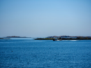 Fototapeta na wymiar A loaded lobster boat heads into the harbor on Vinalhaven Island Maine