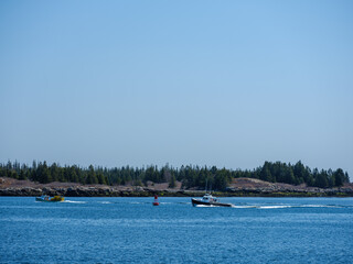 Fototapeta na wymiar A loaded lobster boat heads into the harbor on Vinalhaven Island Maine