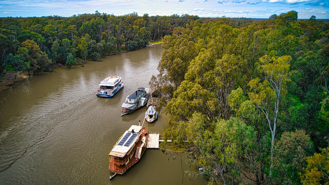 A cruising boat passing some paddle boats on the Murray River at Echuca