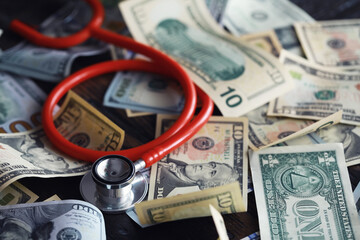 Financial analysis, auditing or business concept. Symbolic image of US Dollar banknotes with stethoscope.