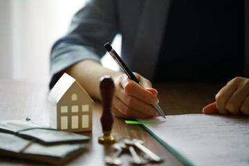Real estate agent talked the terms of the home purchase agreement and asked the customer to sign the documents, Home sales and insurance concept.