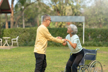Husband helps his elderly wife use a walker to learn to walk elderly couple Asian elderly couple giving love to each other smiling happily love and care for each other