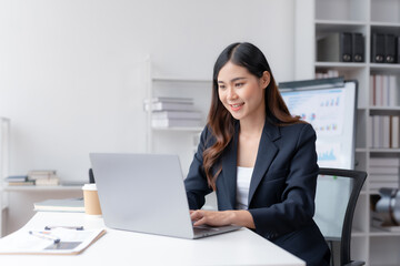Happy smiling Asian businesswoman using laptop computer in the office. Beautiful young Asian female...