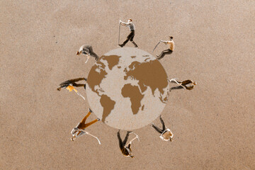 Miniature people standing on the globe with paper background