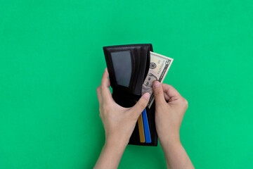 Woman hand holding a leather wallet with dollar - obrazy, fototapety, plakaty