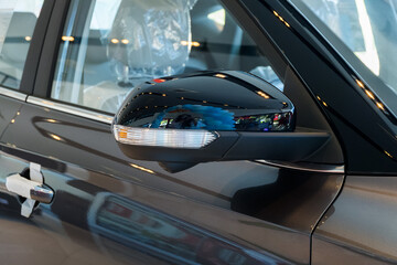 Obraz premium Close up Side mirror on car of black in modern showroom waiting for sales.