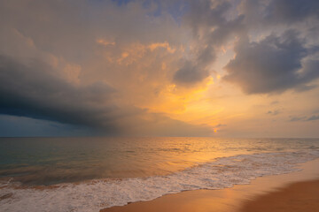 Beautiful evening scenery with sandy ocean beach under a beautiful sunset sky with clouds on Sri Lanka island.