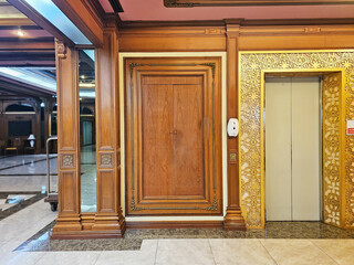 Solid large wooden door with vintage look, teak door, elegant and classy door beside the lift in Bangkok hotel, Thailand. May 15, 2023