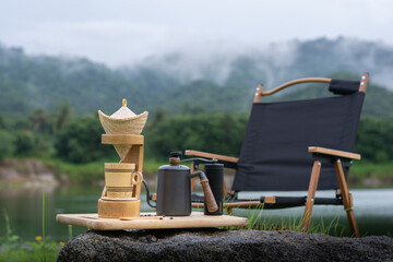 Classic coffee drip set with camping chair in rainy season nature.