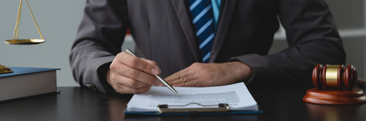 Young lawyer or legal advisor is reading and carefully checking the validity of documents and investment agreements for signing contracts managing justice concepts.