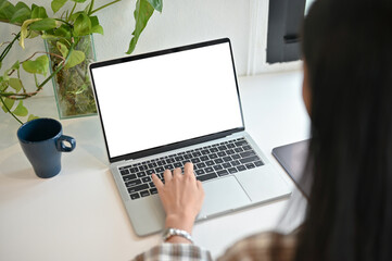 A woman using her laptop computer, working on her work in her office