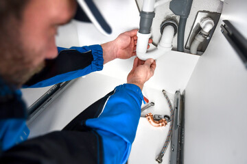 Plumber fixing sink in bathroom. Repair leaking water concept