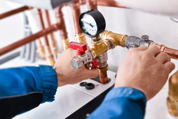 Plumbing concept or service worker. Copper pipelines close up with analog watch pressure water. © Milan