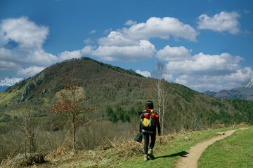 Fototapeta premium woman hiker on mountain trail, back view