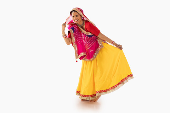 Portrait of Rajasthani woman dancing against white background