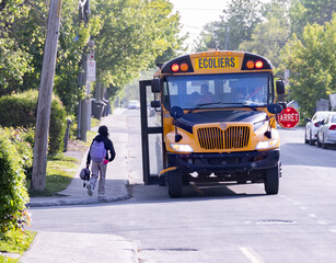 Enfant entrant dans un autobus scolaire - 605567913